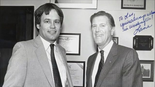 A young Lane Evans in a suit standing in an office beside an older man; the photo is signed by Lane.
